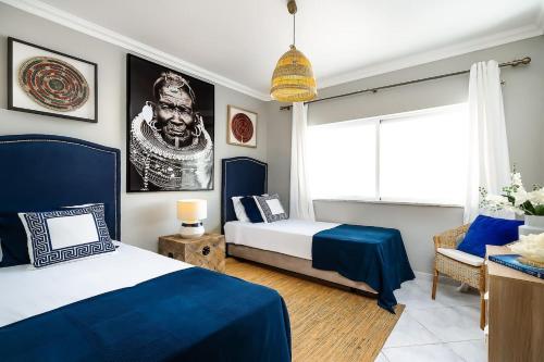 a bedroom with two beds and a couch and a window at Spacious&Bright2Bedroom Apt Near Beaches,Sleeps 6 in Portimão
