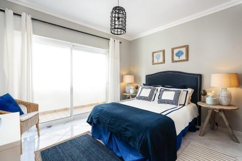 a bedroom with a bed and a large window at Spacious&Bright2Bedroom Apt Near Beaches,Sleeps 6 in Portimão
