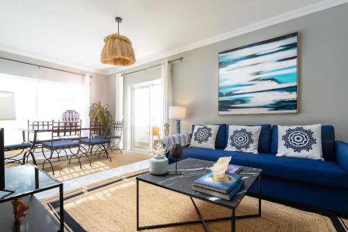 a living room with a blue couch and a table at Spacious&Bright2Bedroom Apt Near Beaches,Sleeps 6 in Portimão