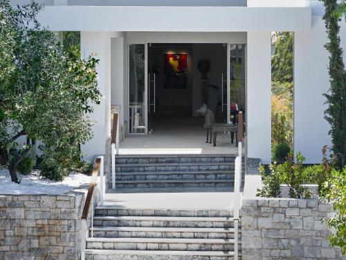 a home with stairs leading to the front door at The Roc Club, A Grecotel Hotel to Live in Athens