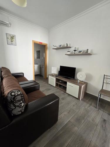 a living room with a couch and a flat screen tv at Casa o Cantinho in Mourão