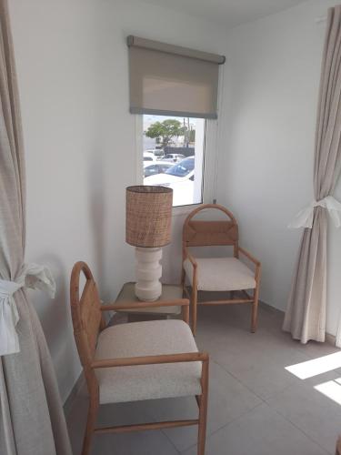 a room with two chairs and a lamp and a window at Kikere Studios in Puerto del Carmen