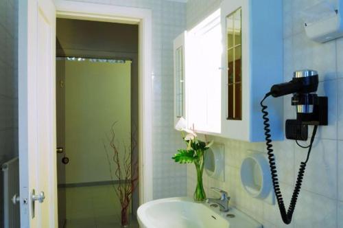 a bathroom with a sink and a phone on the wall at Hotel Villa Giusy in Castellaneta Marina