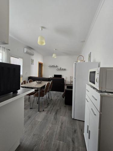 a kitchen and dining room with a table and a refrigerator at Casa o Cantinho in Mourão