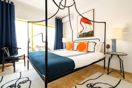 a bedroom with a canopy bed with orange pillows at Stylish Apartment by Rocha Beach, Sleeps 5 in Portimão