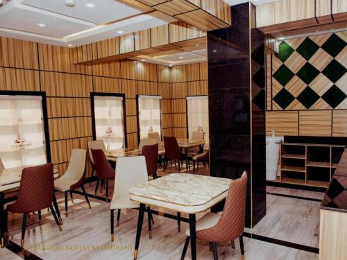 a restaurant with wooden walls and tables and chairs at De Bullion Hotels in Enugu