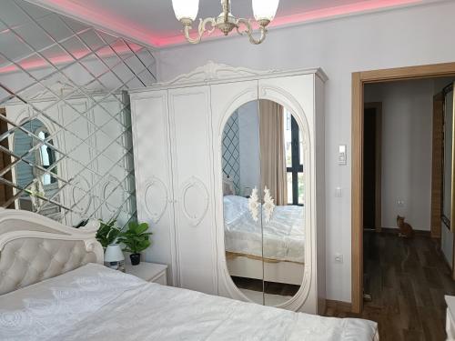 a bedroom with a white bed and a mirror at Cozy flat Азур in Saints Constantine and Helena