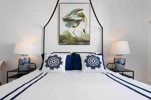 a bedroom with a white bed with blue and white pillows at Spacious Beach 2 bedroom apt sleep6 by promenade in Armação de Pêra