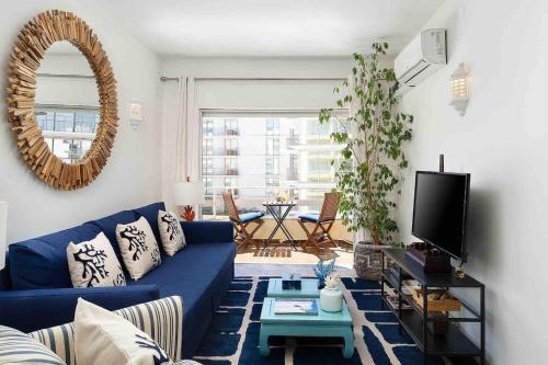 a living room with a blue couch and a mirror at Spacious Beach 2 bedroom apt sleep6 by promenade in Armação de Pêra