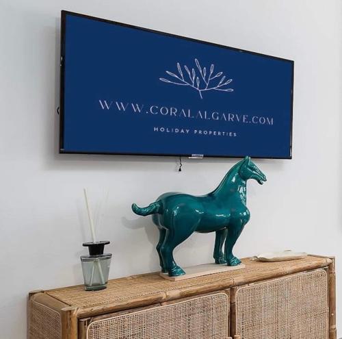 a green horse statue sitting on top of a dresser at Spacious Beach 2 bedroom apt sleep6 by promenade in Armação de Pêra