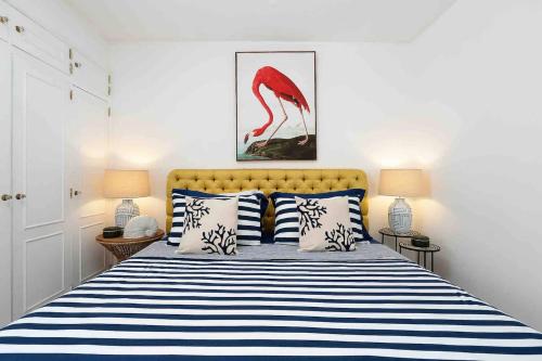 a bedroom with a bed with a red flamingo painting on the wall at Spacious Beach 2 bedroom apt sleep6 by promenade in Armação de Pêra