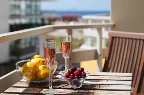 a table with two glasses of champagne and a bowl of fruit at Spacious Beach 2 bedroom apt sleep6 by promenade in Armação de Pêra