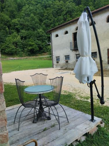 a table and chairs and an umbrella on a deck at Borgo Doccia 905 in Montese