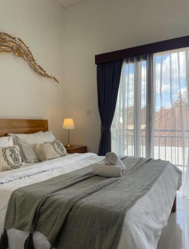 a bedroom with a large bed with a window at Central House Ubud - Private Villa in Ubud