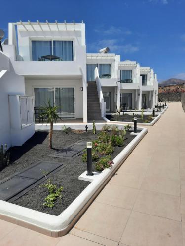 a row of white houses with a sidewalk at Kikere Studios in Puerto del Carmen
