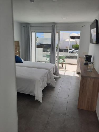 a bedroom with a bed and a view of a balcony at Kikere Studios in Puerto del Carmen