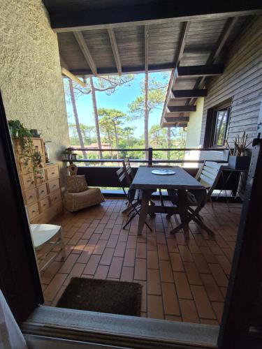 une véranda avec une table et des chaises dans l'établissement Seignosse Appart T2 - 500m Océan, à Hossegor