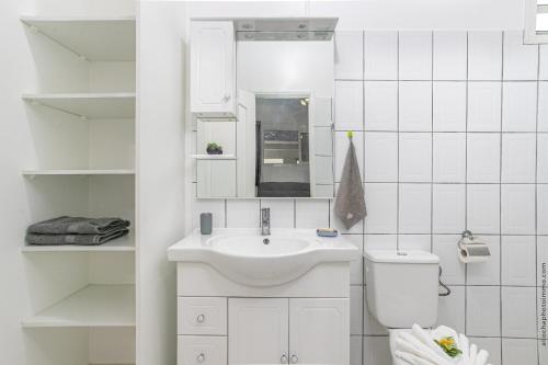 a white bathroom with a sink and a toilet at Basilic au Refuge de Madiana à Schoelcher in Schœlcher