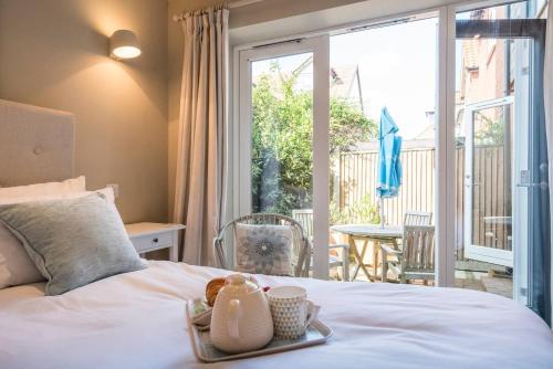 a bedroom with a bed with a tray of food on it at Captain's Quarters, a ground floor apartment in Aldeburgh in Aldeburgh