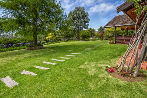 a lawn with stepping stones in a yard at Piesang Valley Lodge in Plettenberg Bay