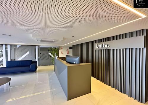 an office lobby with a blue couch and a desk at LM Unity Cabo branco in Penha