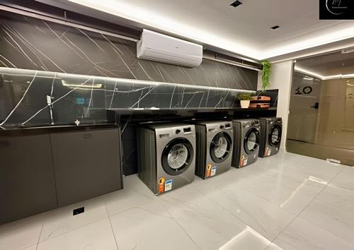 a laundry room with three washing machines in it at LM Unity Cabo branco in Penha