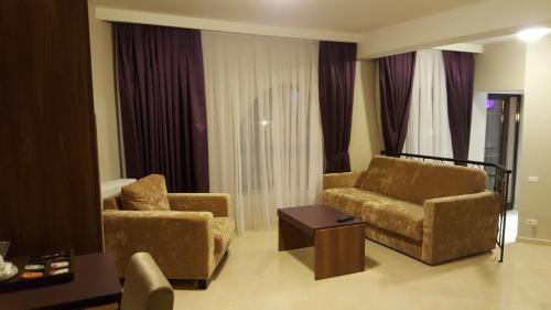 a living room with two chairs and a table at Hotel Miruna - New Belvedere in Poiana Brasov