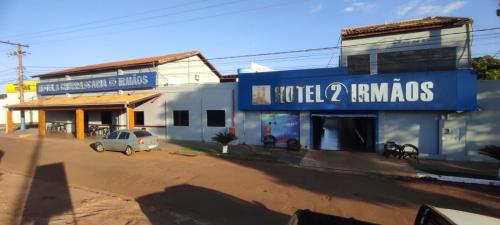 a blue building with a car parked in front of it at Hotel 2 Irmãos in Campo Grande
