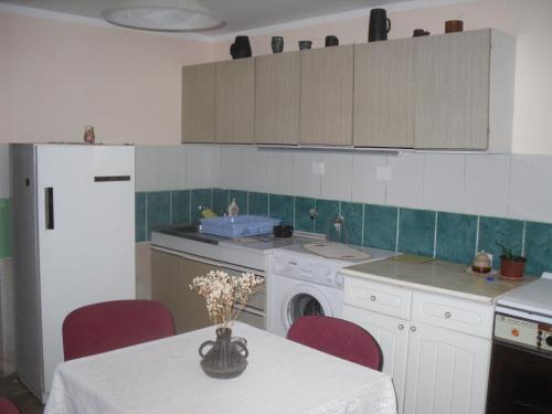 a kitchen with a table with red chairs and a sink at Guest House Keserovic in Vinci