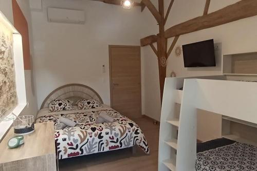 une chambre avec un lit et une télévision au mur dans l'établissement Ô Rev, à Chambretaud