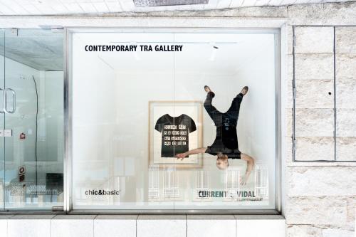 a woman is jumping in a store window at chic&basic Gravity in Porto