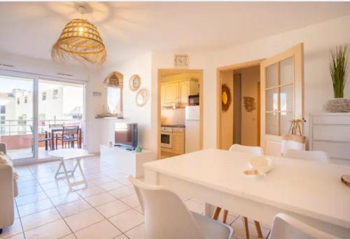 une cuisine et une salle à manger avec une table et des chaises blanches dans l'établissement APPARTEMENT T2- Terrasse- vue dégagée -Centre ville-Tout à pieds- L Impérial, à Saint-Raphaël