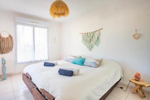 - une chambre avec un grand lit blanc et des oreillers dans l'établissement APPARTEMENT T2- Terrasse- vue dégagée -Centre ville-Tout à pieds- L Impérial, à Saint-Raphaël