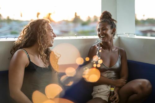two women sitting on a balcony talking and laughing at Kite Active Paje in Paje