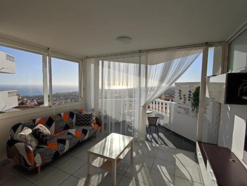 a living room with a couch and a large window at 16 Sunset view in Adeje