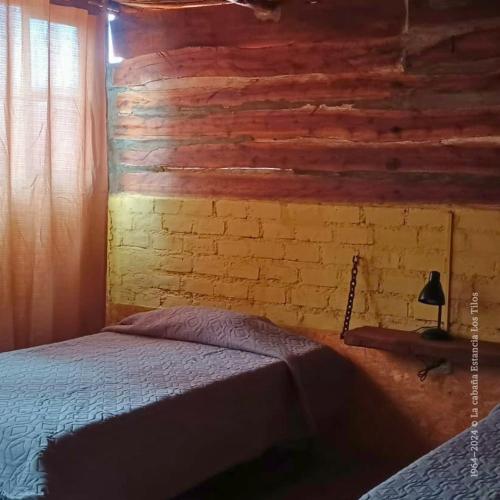 a bedroom with a bed and a brick wall at La cabaña estancia Los Tilos in Hacienda Santo Domingo
