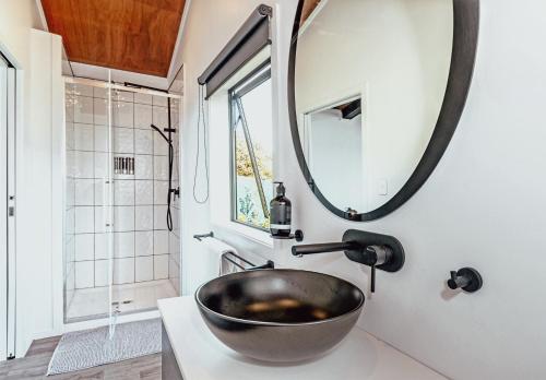 a bathroom with a bowl sink and a mirror at Black Label Retreats in Gisborne