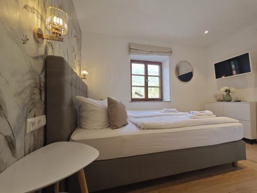a small bedroom with a bed with a window at Hotel garni Königslinde - Wandern, Radeln, Skifahren & Genießen in Bayrischzell