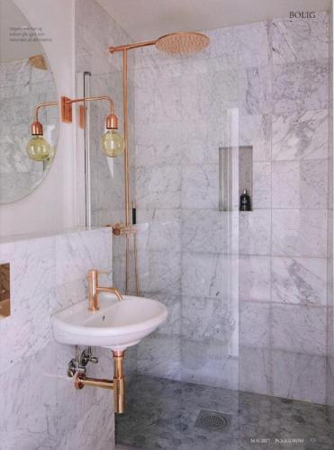 a white bathroom with a sink and a shower at Villa Solgården in Hanko