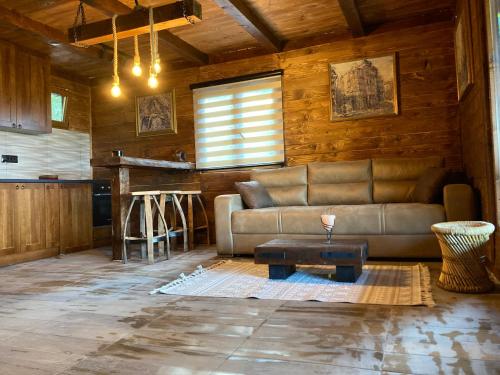 a living room with a couch and a table at Brvnara Leska in Jarmenovci