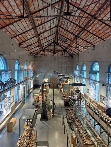 une grande chambre avec beaucoup de tables et de fenêtres dans l'établissement Rez de villa à la campagne, à Générargues
