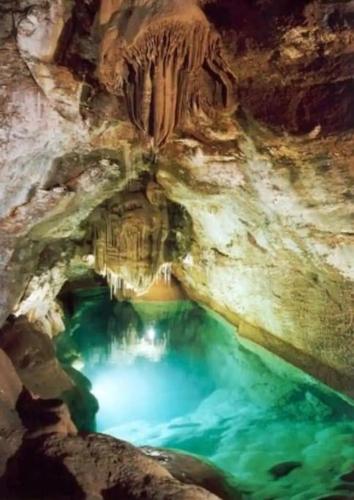 - une grande piscine d'eau bleue dans une grotte dans l'établissement Rez de villa à la campagne, à Générargues