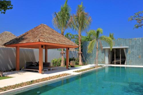 a swimming pool with a gazebo next to a house at New luxury villa with maid Anchan Tropicana in Bang Tao Beach