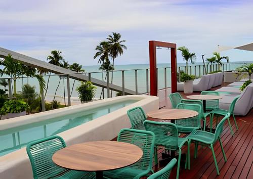 a patio with tables and chairs next to a swimming pool at LM Setai Yacht Cabo Branco in Tambaú