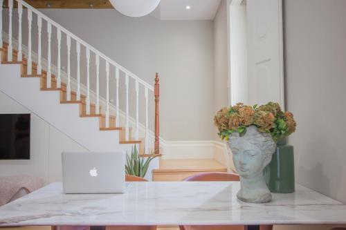 a table with a vase of flowers on top of it at Casa do Visconde by Guestify in Guimarães
