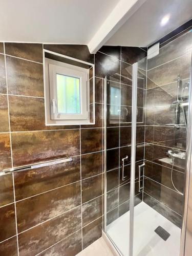 La salle de bains est pourvue d'une douche et d'une fenêtre. dans l'établissement 9 écluses Canal du midi-Maison T3 belle vue avec Piscine, à Béziers