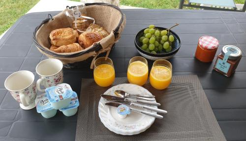 - une table avec petit-déjeuner composé de croissants et de jus d'orange dans l'établissement Gîte et piscine l'écrin aux oliviers en Cévennes, à Saint-Christol-lès-Alès