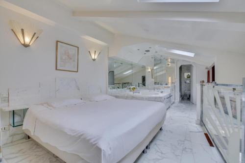 - une chambre blanche avec deux lavabos et un grand lit dans l'établissement Louvre Terrace Apartment, à Paris