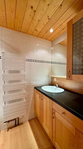 La salle de bains est pourvue d'un lavabo et d'un comptoir. dans l'établissement Appt résidence 1650 ski aux pieds, à Courchevel