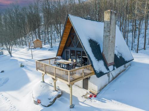 a house with a deck in the snow at 5 Bedrooms House with Hunter Mountain View and Large Hot Tub in Lanesville